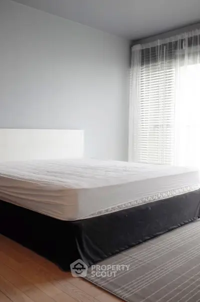 Spacious bedroom with large window and modern decor