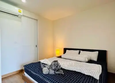 Cozy bedroom with modern decor and air conditioning in a stylish apartment.