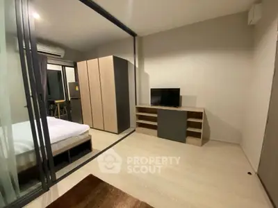 Modern bedroom with glass partition and sleek furniture in a stylish apartment.