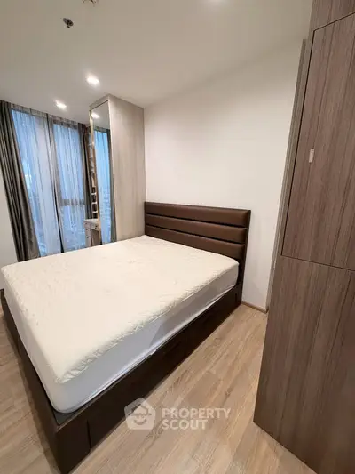 Modern bedroom with wooden flooring and stylish bed in a cozy apartment.