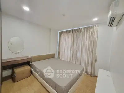 Modern bedroom with large window and minimalist decor in a cozy apartment