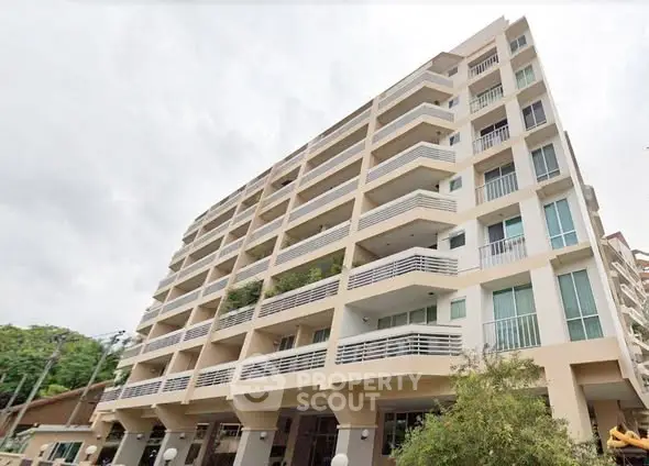 Modern multi-story apartment building with spacious balconies and contemporary design.