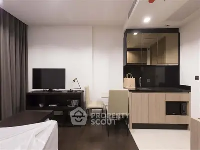 Modern studio apartment with compact kitchen and cozy living area.