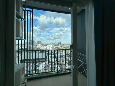 Stunning city view from a high-rise balcony with clear skies and modern railing.