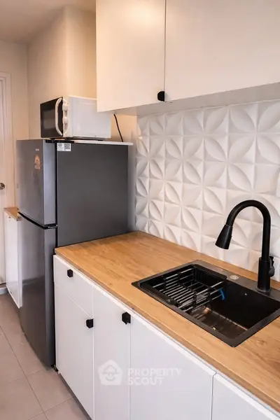 Modern kitchen with sleek cabinetry, stylish backsplash, and stainless steel appliances.