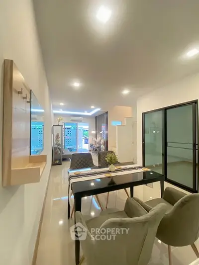 Modern open-plan living and dining area with sleek furniture and bright lighting.