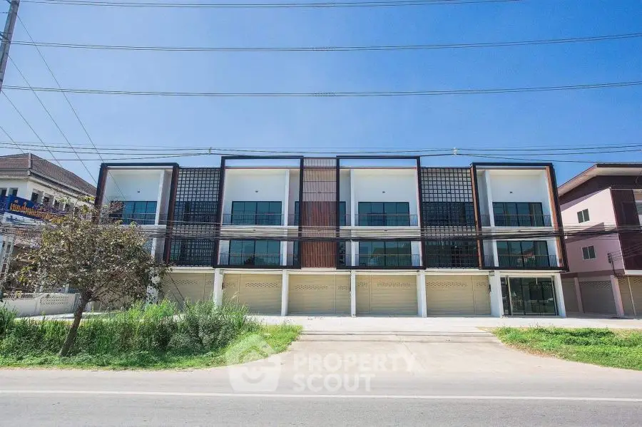 Modern townhouse exterior with sleek design and spacious parking area.