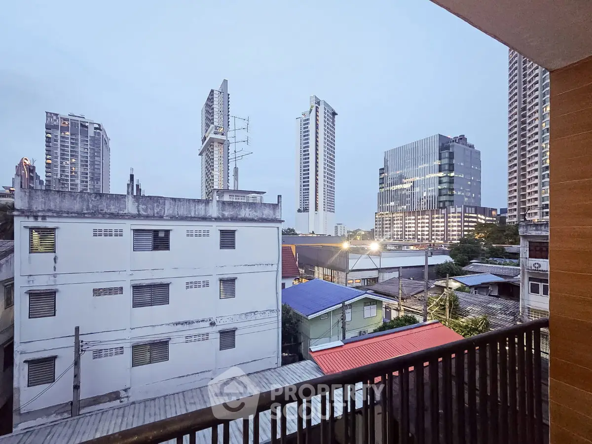Stunning urban view from a balcony overlooking city skyline with modern high-rise buildings.