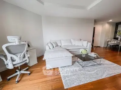 Modern living room with sleek white furniture and hardwood floors, perfect for stylish urban living.