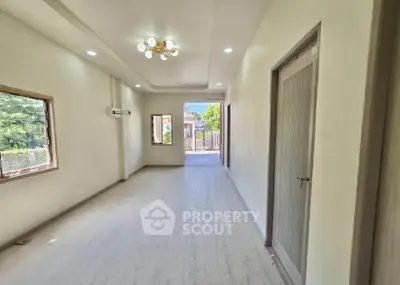 Spacious living room with modern lighting and large windows offering natural light.