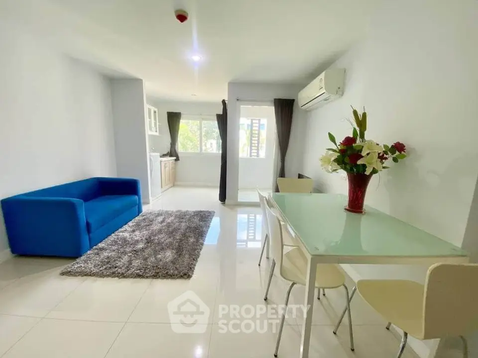 Bright modern living room with blue sofa and dining area in open layout