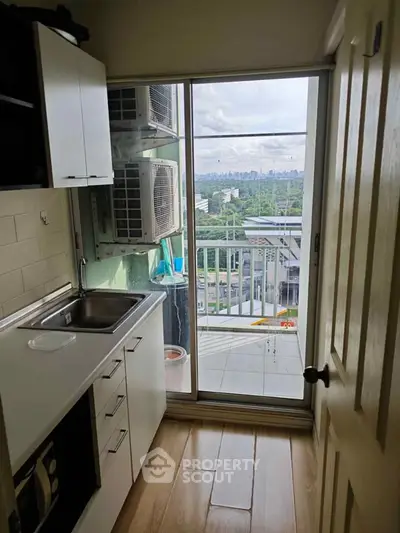 Compact kitchen with balcony view in modern apartment