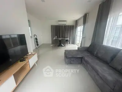 Spacious modern living room with sleek furniture and large windows for natural light.