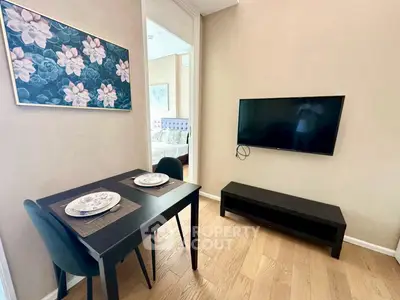 Cozy dining area with wall-mounted TV and elegant decor in modern apartment.