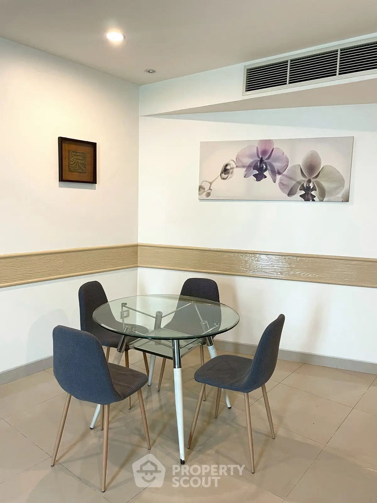 Modern dining area with glass table and stylish chairs in a contemporary apartment.