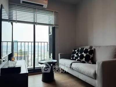 Modern living room with city view, stylish sofa, and sleek decor.