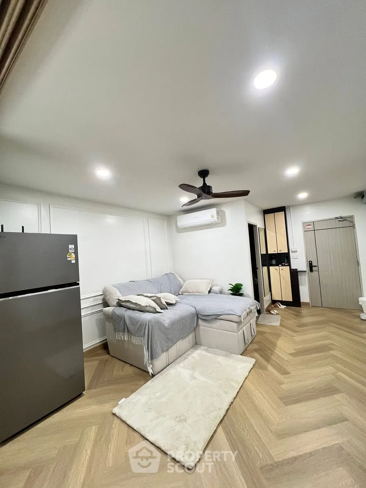 Modern living room with cozy sofa and sleek refrigerator