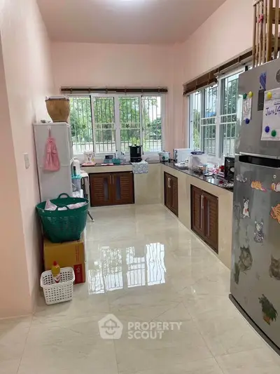 Spacious kitchen with modern appliances and large windows for natural light.