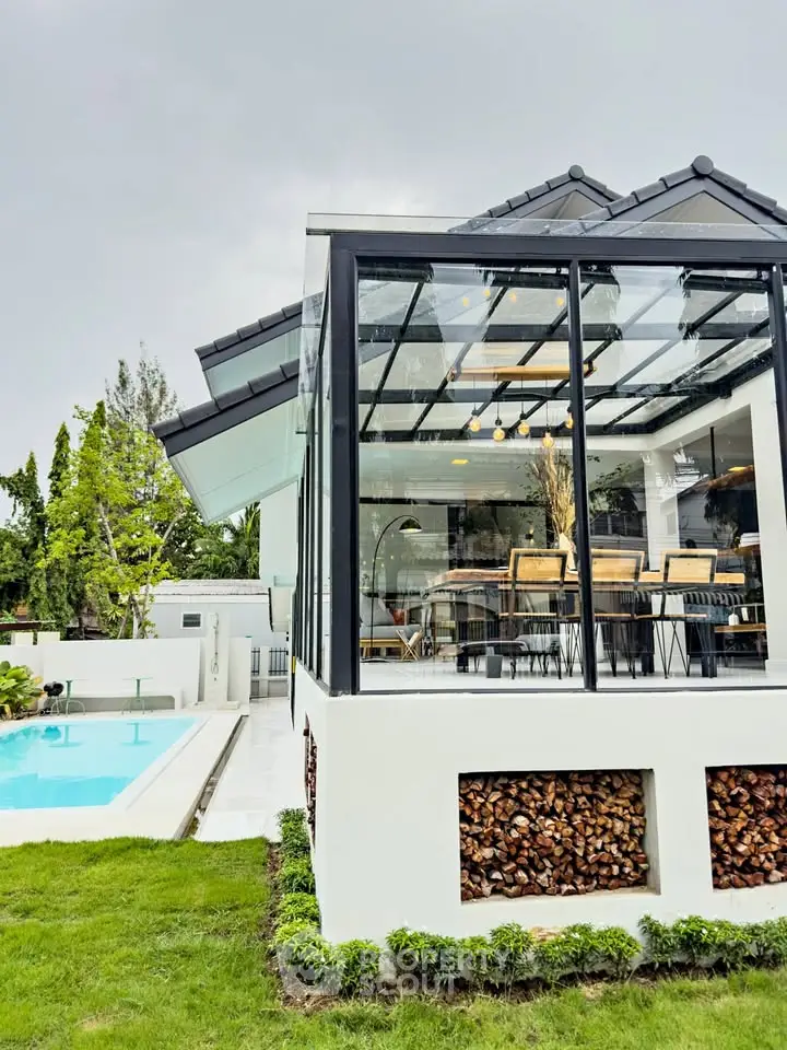 Modern glass house with pool and lush garden, perfect for luxury living.