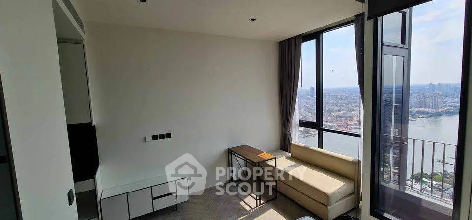 Modern living room with stunning city view and large windows, featuring a cozy sofa and sleek furniture.
