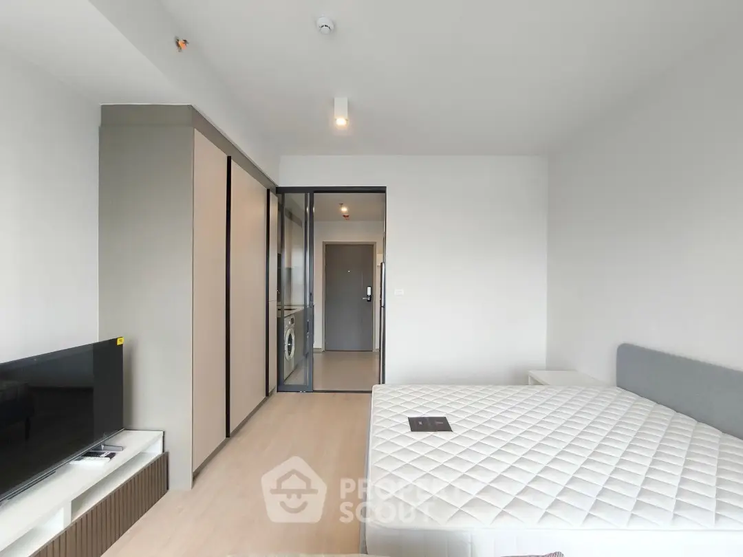 Modern bedroom with sleek design, featuring a comfortable bed and built-in storage, perfect for urban living.