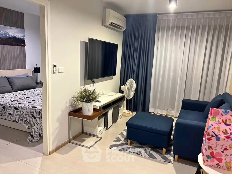 Modern living room with cozy seating and stylish decor, adjacent to a chic bedroom.