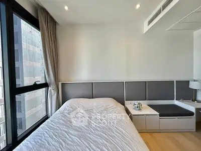 Modern bedroom with large window and sleek furniture in urban apartment
