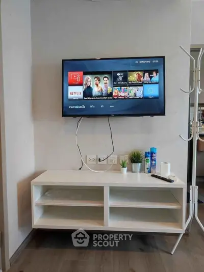 Modern living room with wall-mounted TV and sleek white console, perfect for entertainment and relaxation.