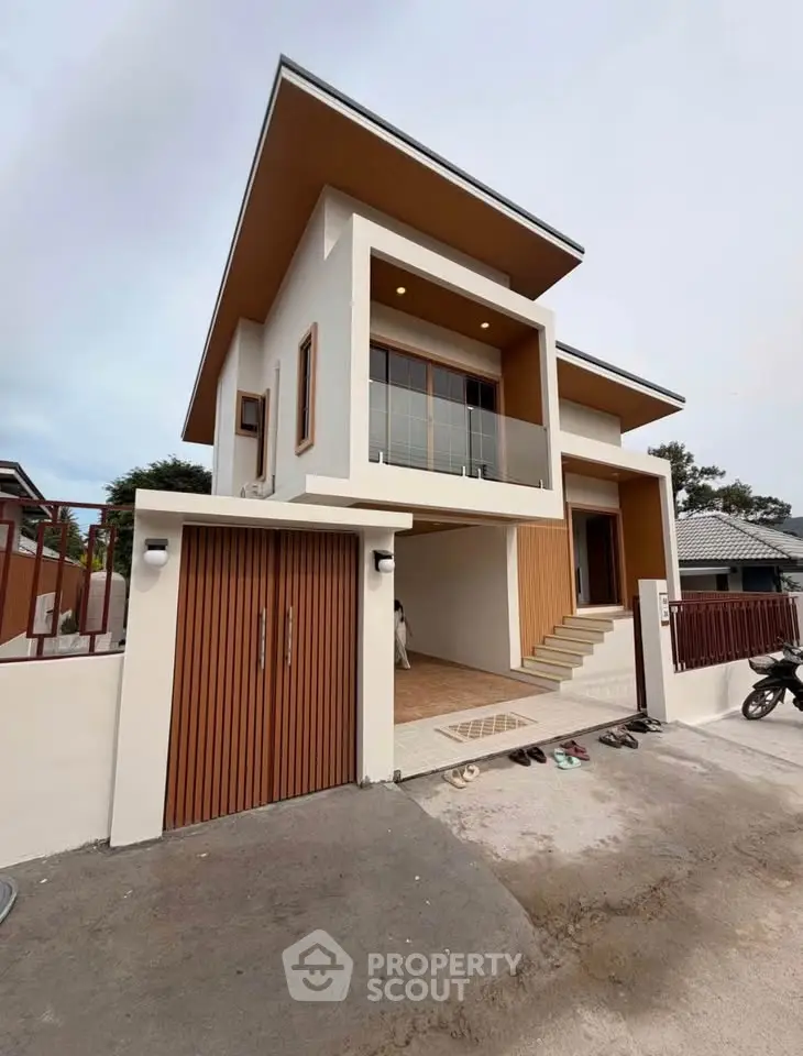 Modern two-story house with unique architectural design and spacious balcony.