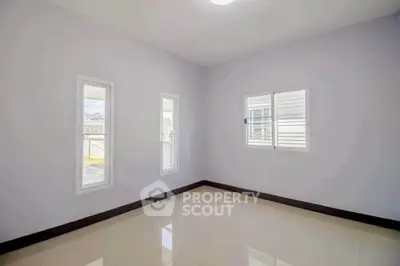 Spacious empty room with large windows and glossy tiled floor, perfect for customization.