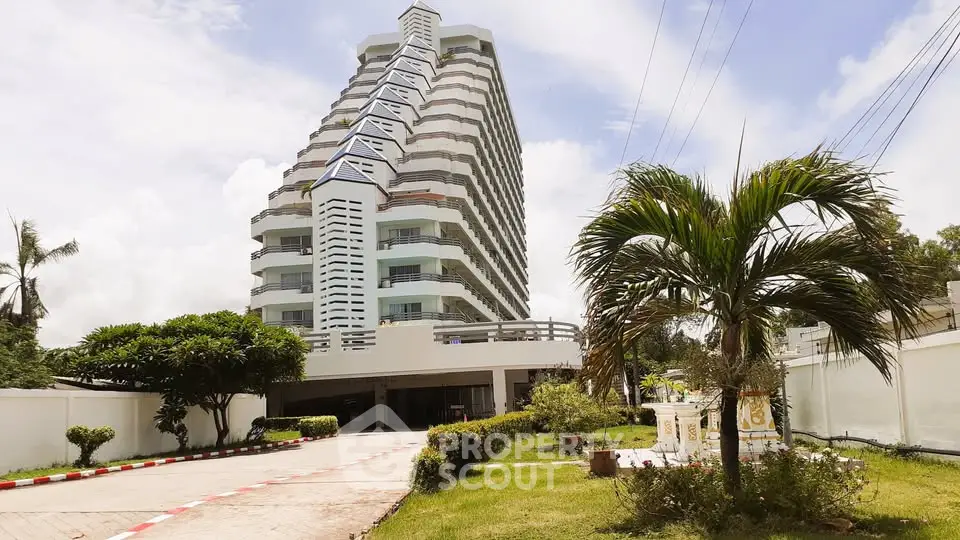 Stunning modern high-rise building with lush landscaping and clear blue sky.