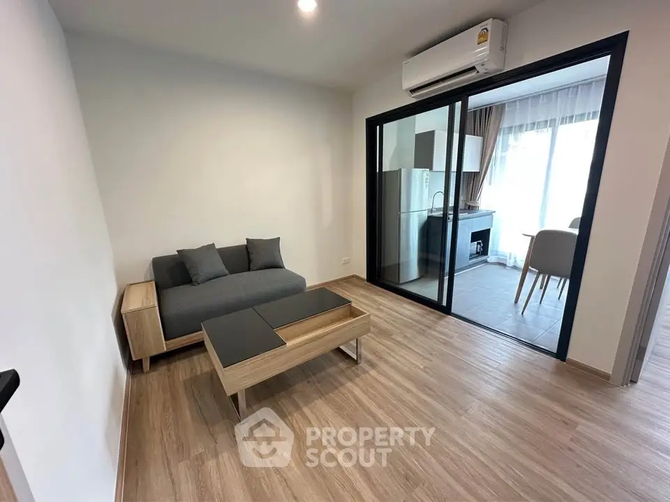 Modern living room with sleek furniture and open kitchen layout in a stylish apartment.