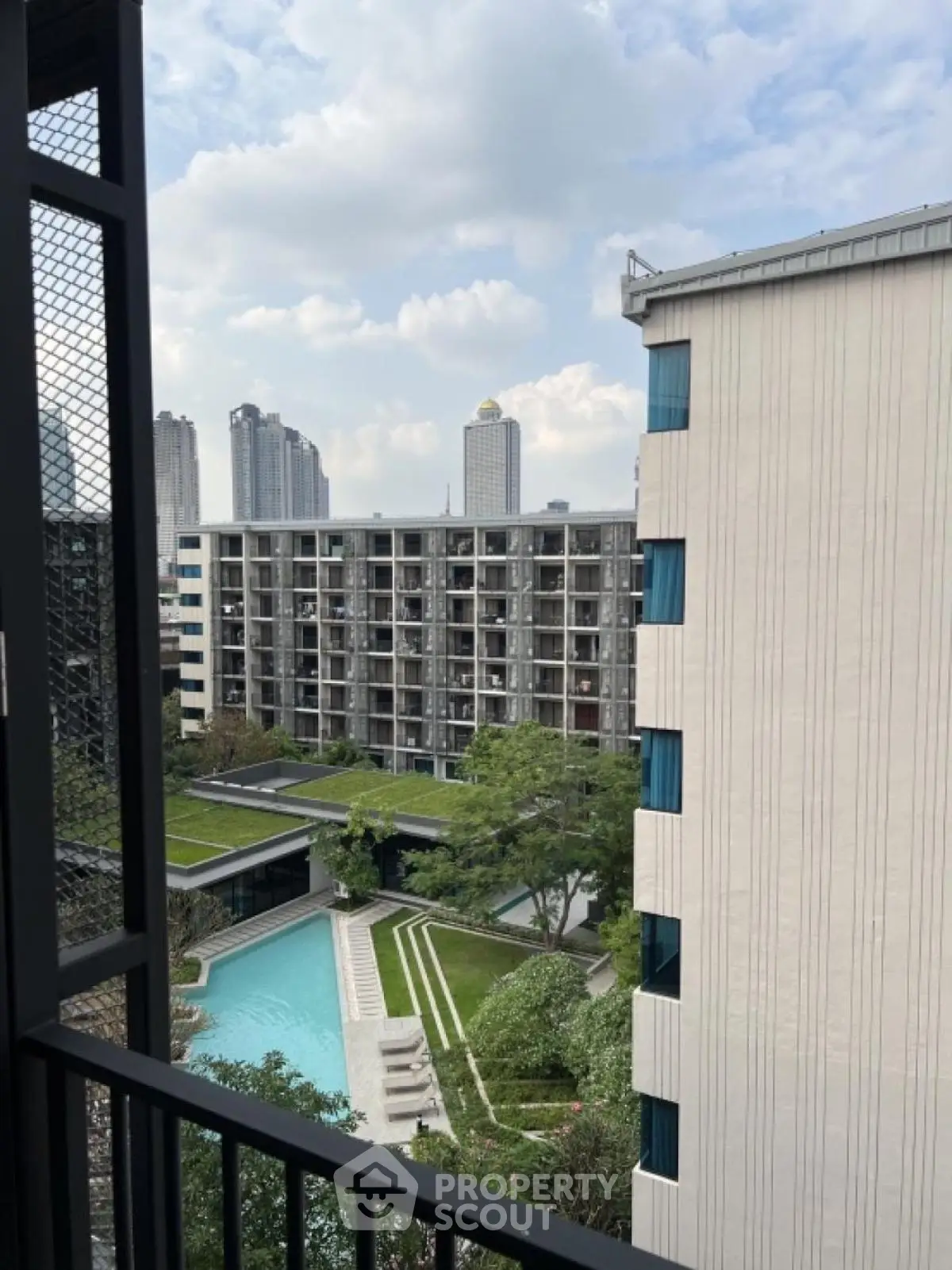 Modern urban apartment complex with pool and city skyline view