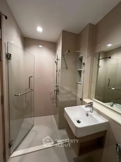 Modern bathroom with glass shower enclosure and sleek sink design