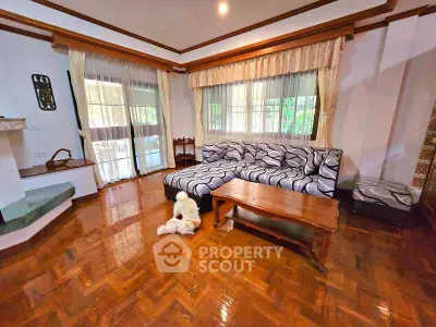 Spacious living room with elegant wooden flooring and large windows.