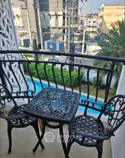Charming balcony with elegant wrought iron furniture and city view, perfect for relaxation.