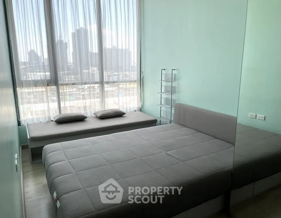 Modern bedroom with large window and city view, featuring a stylish bed and minimalist decor.