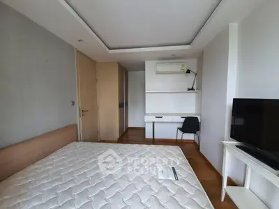 Modern bedroom with wooden flooring, built-in desk, and air conditioning unit.