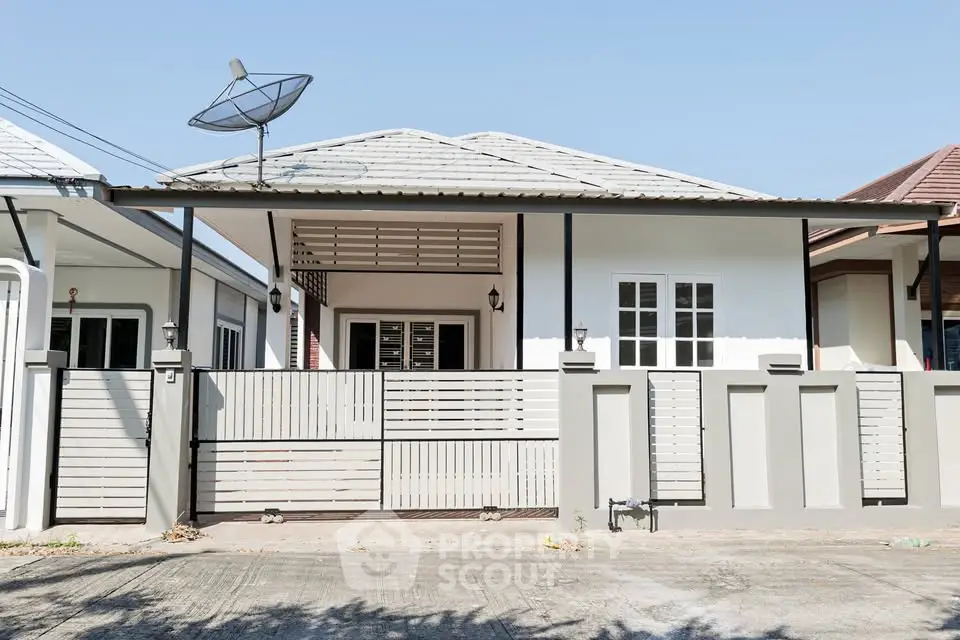 Charming single-story house with satellite dish and gated entrance