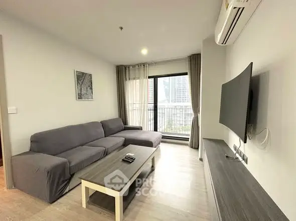 Modern living room with sleek furniture and city view balcony in a high-rise apartment.