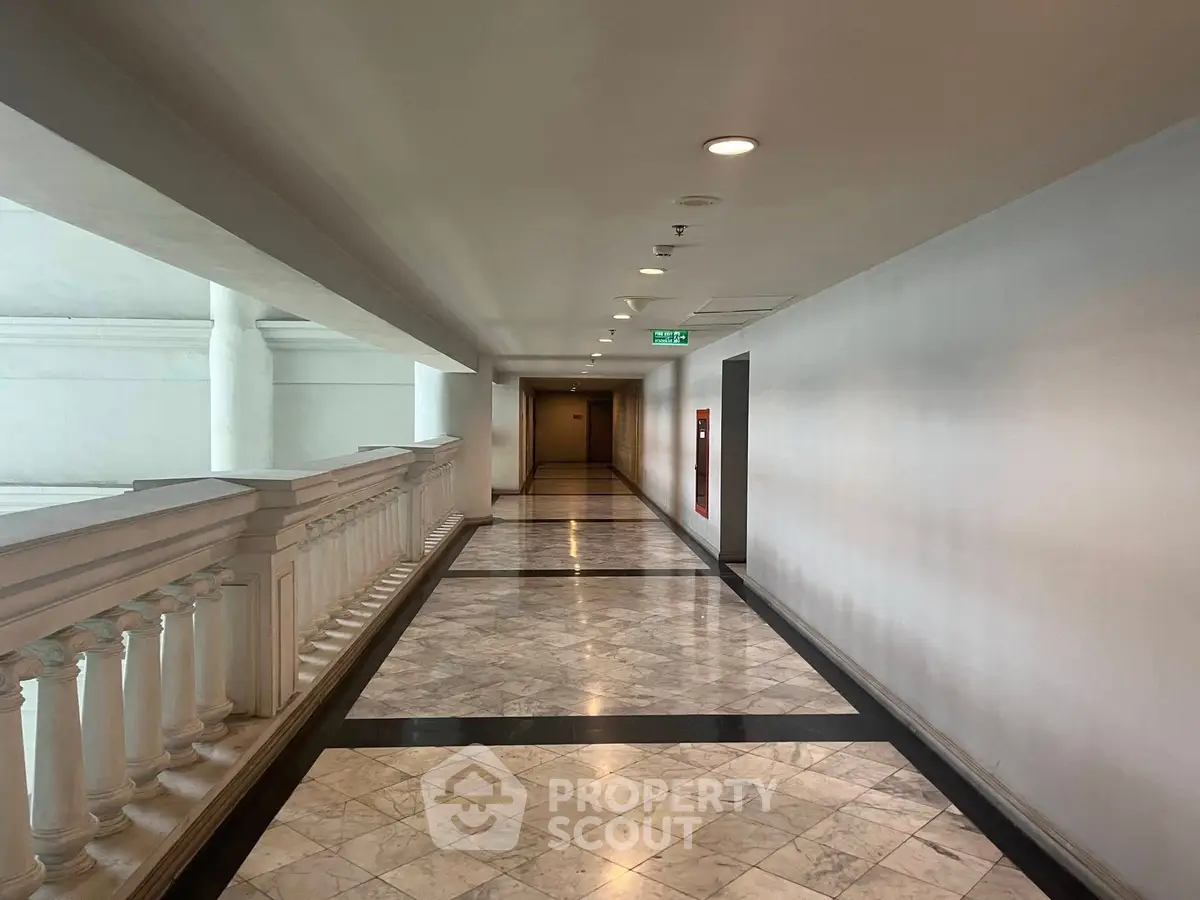 Elegant corridor with marble flooring and classic railing in a luxurious building.