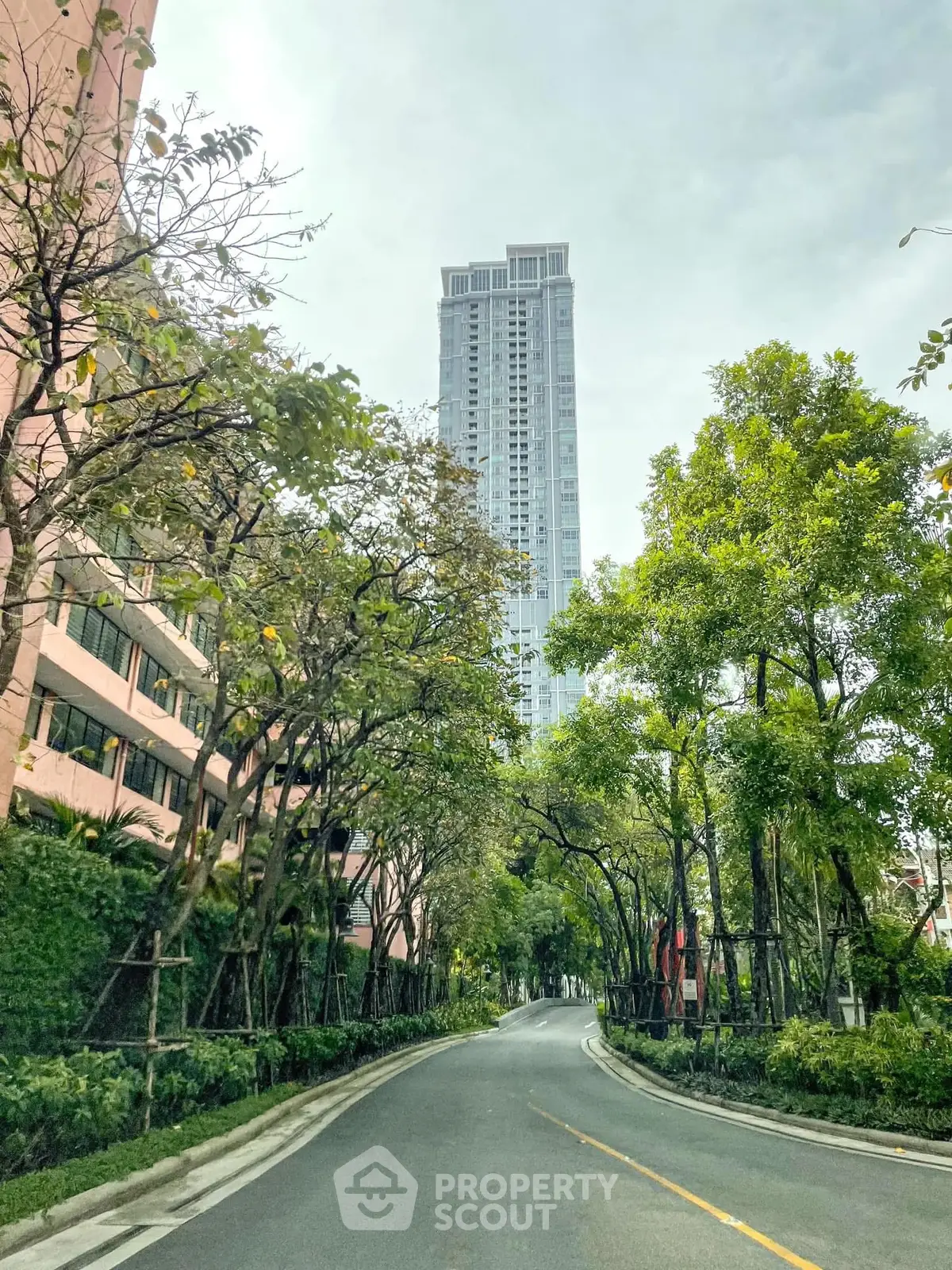 Stunning high-rise building surrounded by lush greenery and a winding road
