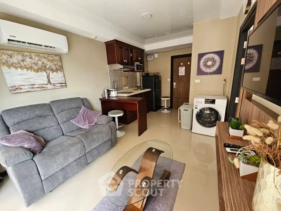 Modern living room with cozy sofa, stylish decor, and compact kitchen area.