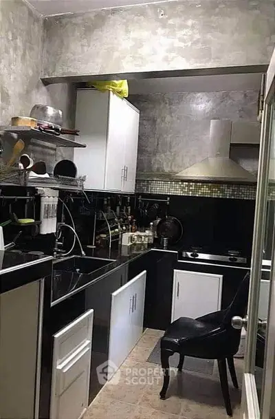 Compact kitchen with modern appliances and sleek black and white cabinetry.
