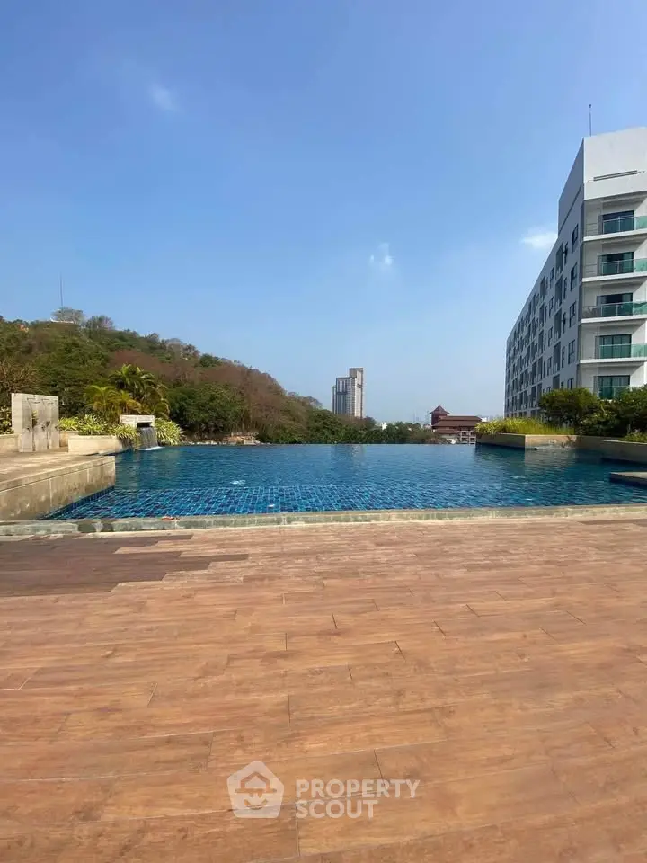 Luxurious poolside view with modern building and scenic landscape