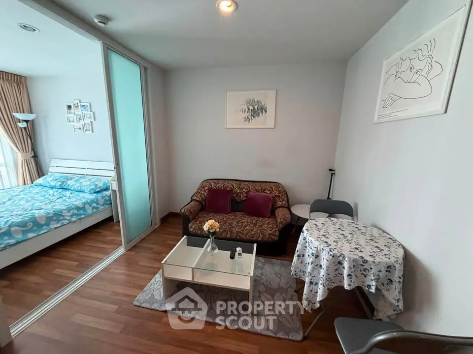 Cozy living room with modern decor and adjacent bedroom in a stylish apartment.