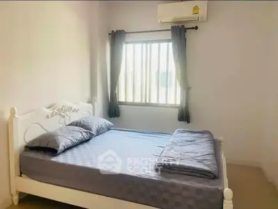 Cozy bedroom with natural light and air conditioning, perfect for relaxation.