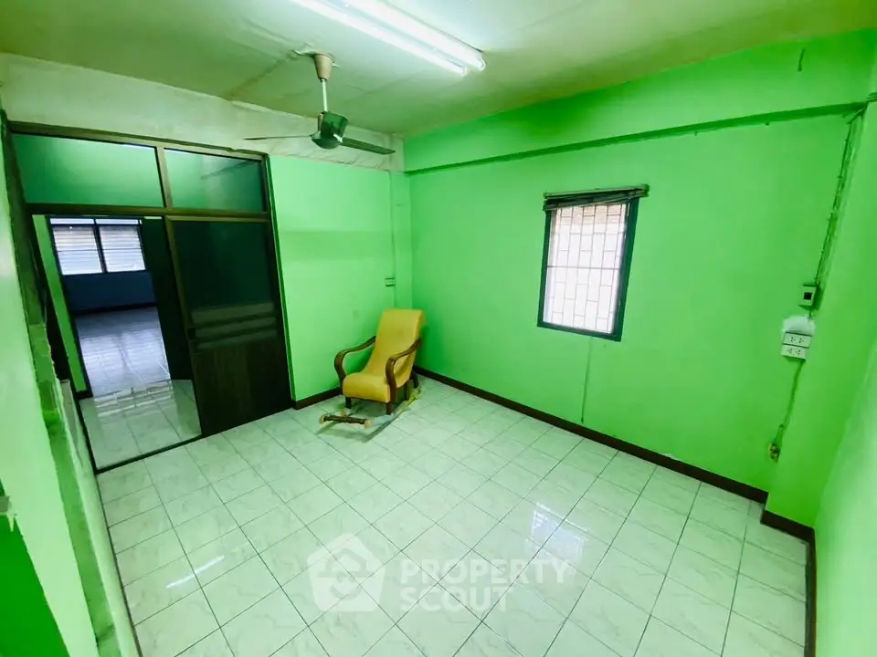 Bright green room with tiled floor and single chair, ideal for creative interior design.