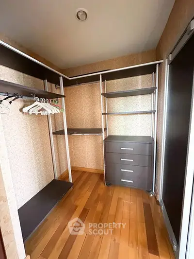 Spacious walk-in closet with wooden flooring and modern shelving