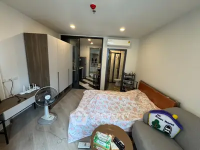 Cozy studio apartment with modern furnishings and open layout, featuring a comfortable bed and stylish decor.